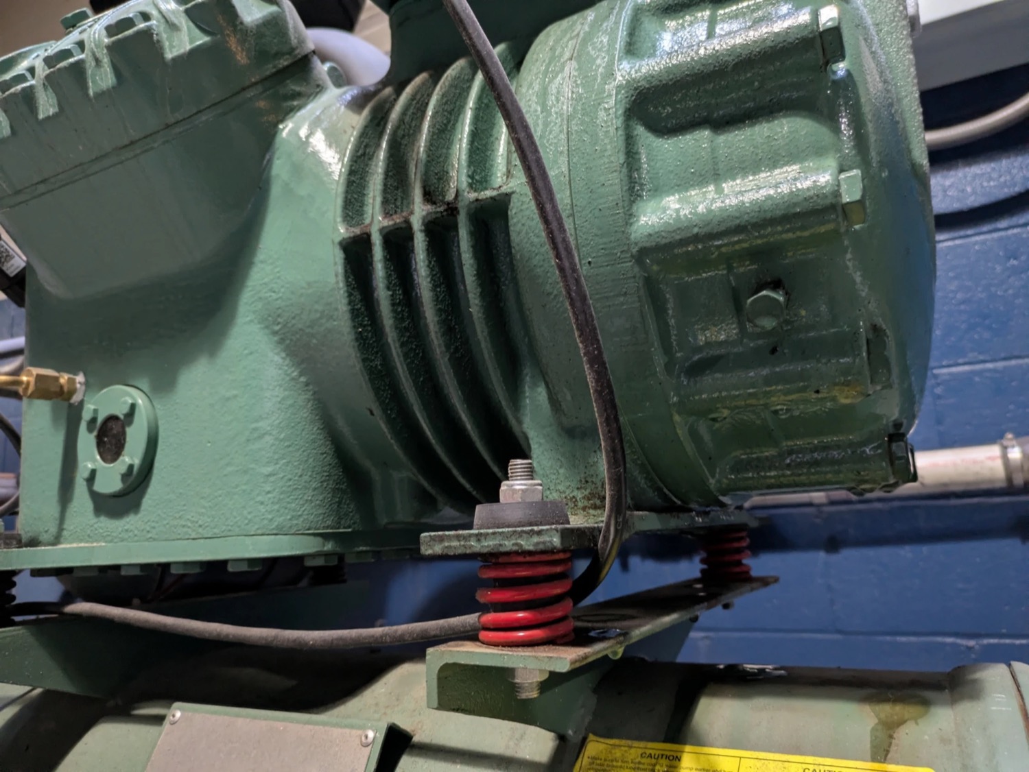 Industrial compressor supported on spring vibration-isolation mounts